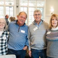Four event attendees standing together and posing for photo